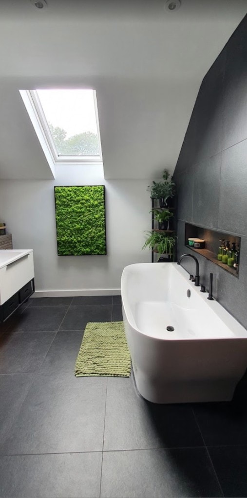 Premium bathroom with freestanding bath, moss wall feature and matte black fixtures