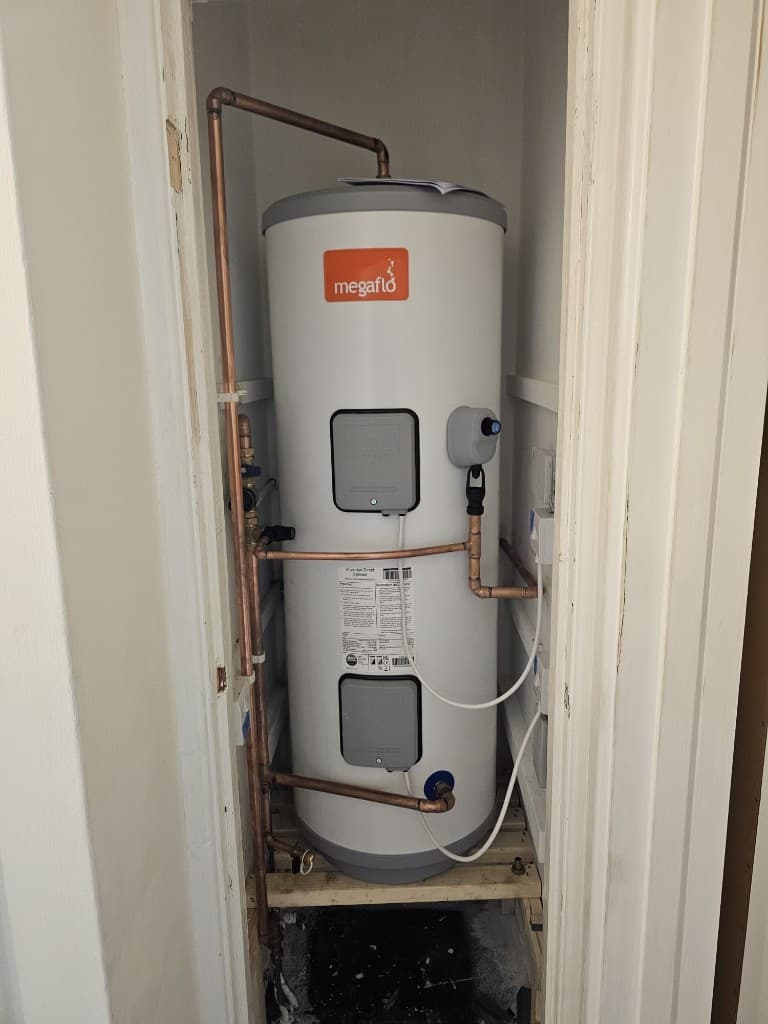 Megaflo unvented cylinder installed in a utility cupboard by APS Plumbing
