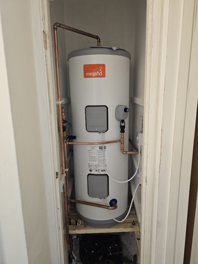 Megaflo unvented cylinder installed in a utility cupboard by APS Plumbing